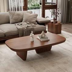 a living room with couches, coffee table and vases on the floor in front of large windows