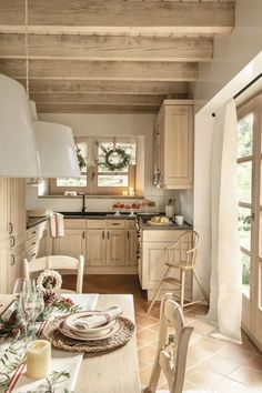 a dining room table with place settings on it in front of an open kitchen door