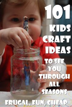 a young child holding a toothbrush in a jar