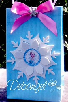 a blue gift bag with a pink bow on the top and an image of a snowflake