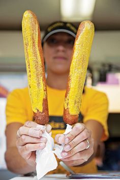 a person holding two hot dogs in their hands while they are ready to eat them