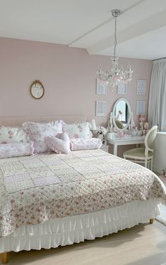 a bedroom with pink walls, white furniture and a chandelier hanging from the ceiling