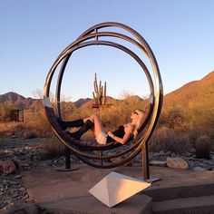 a woman laying on top of a metal sculpture