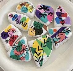 painted rocks in the shape of flowers on a plate