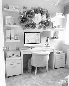 black and white photograph of a home office with flowers on the wall above the desk