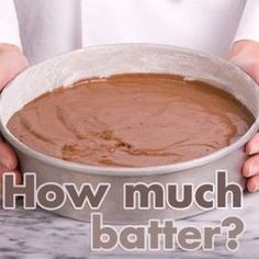 a person holding a bowl with chocolate in it on a marble counter top, while wearing a white coat