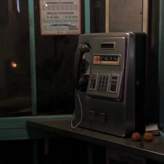 an old style pay phone sitting on top of a counter next to a sign that says don't call