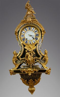 an ornate gold and black clock with figures on the front, against a gray background