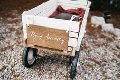 a wooden wagon with the word ring security on it's side sitting in gravel