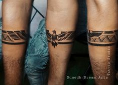 two men's legs with tattoos on them, one has an eagle and the other has a bird