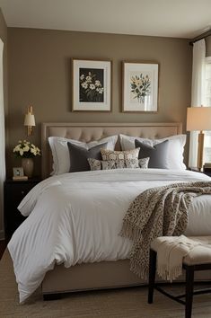 a large bed sitting in a bedroom next to two pictures on the wall above it