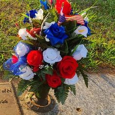 an american flag arrangement in a vase next to a grave marker with the words memorial written on it