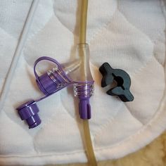 two purple and black objects laying on top of a white blanket