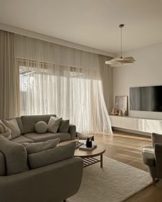 a living room filled with furniture and a flat screen tv mounted on the wall above it