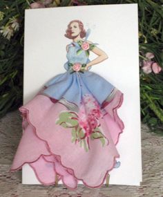 a card with a woman's dress and flowers on it