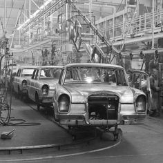 an assembly line with cars being worked on