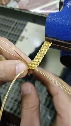 a person is working on a gold chain