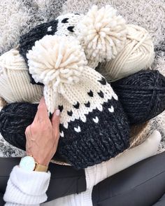 a person is holding onto some knitted items