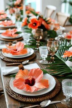 the table is set with plates, silverware and orange flower centerpieces on each plate