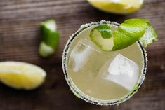 a close up of a drink with limes on the side