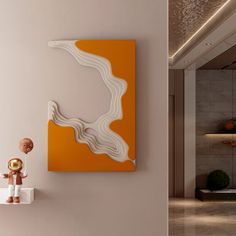 an orange and white painting hangs on the wall next to a teddy bear sitting on a shelf