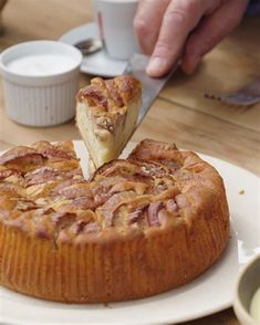 a person is cutting into a cake on a plate