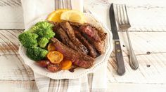 steak, broccoli and tomatoes on a plate with a fork next to it