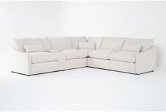 a white sectional sofa with pillows on the top and bottom corner, in front of a white background