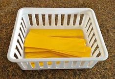 a white basket filled with yellow envelopes