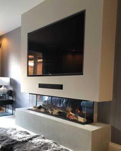 a flat screen tv mounted to the side of a wall next to a fire place