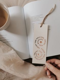 an open book with some writing on it next to a cup of coffee and a napkin