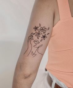 a woman's arm with a flower tattoo on the left side of her arm