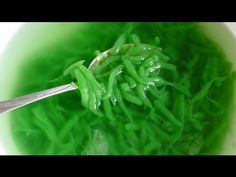 a close up of a spoon with some green food in it