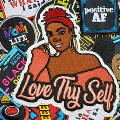 a patch with the words love thy self surrounded by various stickers and magnets