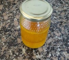 a glass jar filled with liquid sitting on top of a granite countertop next to a metal lid