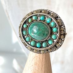 Large, dark green cabochon, set in hand made bezel, is likely turquoise surrounded by turquoise  beads. Originally a bright brass, this would polish to a shine. Ornate filigree with brass beaded details. A quality hand made brooch from the early 20th century. Can be worn as a brooch or a pendant.  Details:  * Era: Early 20th Century * Metal: Brass * Clasp: Early Safety * Stones: Green Stone or Turquoise * Mark/Signature: None * Victorian Measurements: Width 1.375 in Length 1.5 in Dimensions approximate. Good antique condition.  Vintage jewelry arrives nicely packaged for gifting or storing. Find more sparkly goodness at hellosparkly.com. Victorian Green, Green Stone, Turquoise Beads, Early 20th Century, Brooch Pin, Dark Green, 20th Century, Vintage Jewelry, Women Jewelry