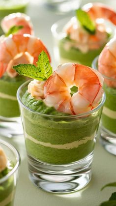 several small cups filled with food and garnished with green leafy garnishments