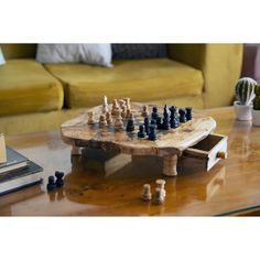 a wooden chess board sitting on top of a coffee table next to a cactus plant