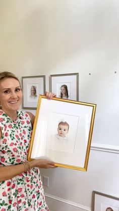 a woman is holding up a framed photo