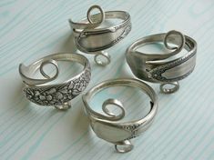 four silver rings sitting on top of a table