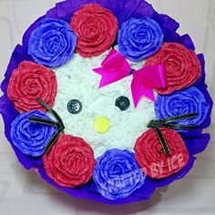 a cake decorated like a cat with roses on it's face and eyes in the shape of flowers