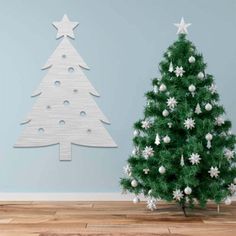 a white christmas tree next to a wooden cutout