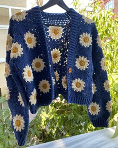 a blue sweater with white and yellow flowers on it