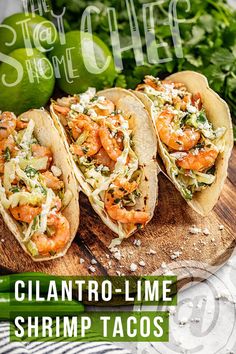 three shrimp tacos sitting on top of a wooden cutting board