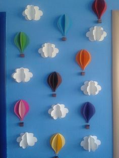 there are many hot air balloons in the sky on this blue wall with clouds and clouds