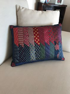 a colorful patchwork pillow sitting on top of a couch