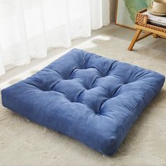 a blue square cushion on the floor