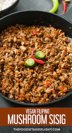 vegan flipping mushroom sisig in a cast iron skillet with peppers and jalapenos