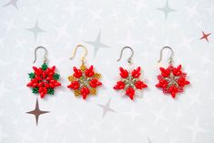 three pairs of red and green earrings on a white surface with stars in the background