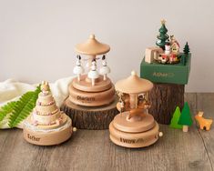 three wooden toy carousels sitting next to each other on top of a wooden table